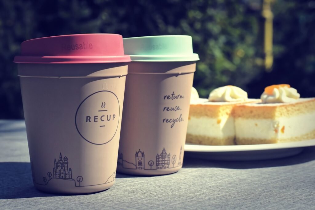 Two paper cups with reduce, reuse, recycle written on it