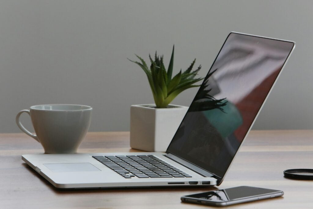 Silver Laptop and White Cup on Table to show impact of technology