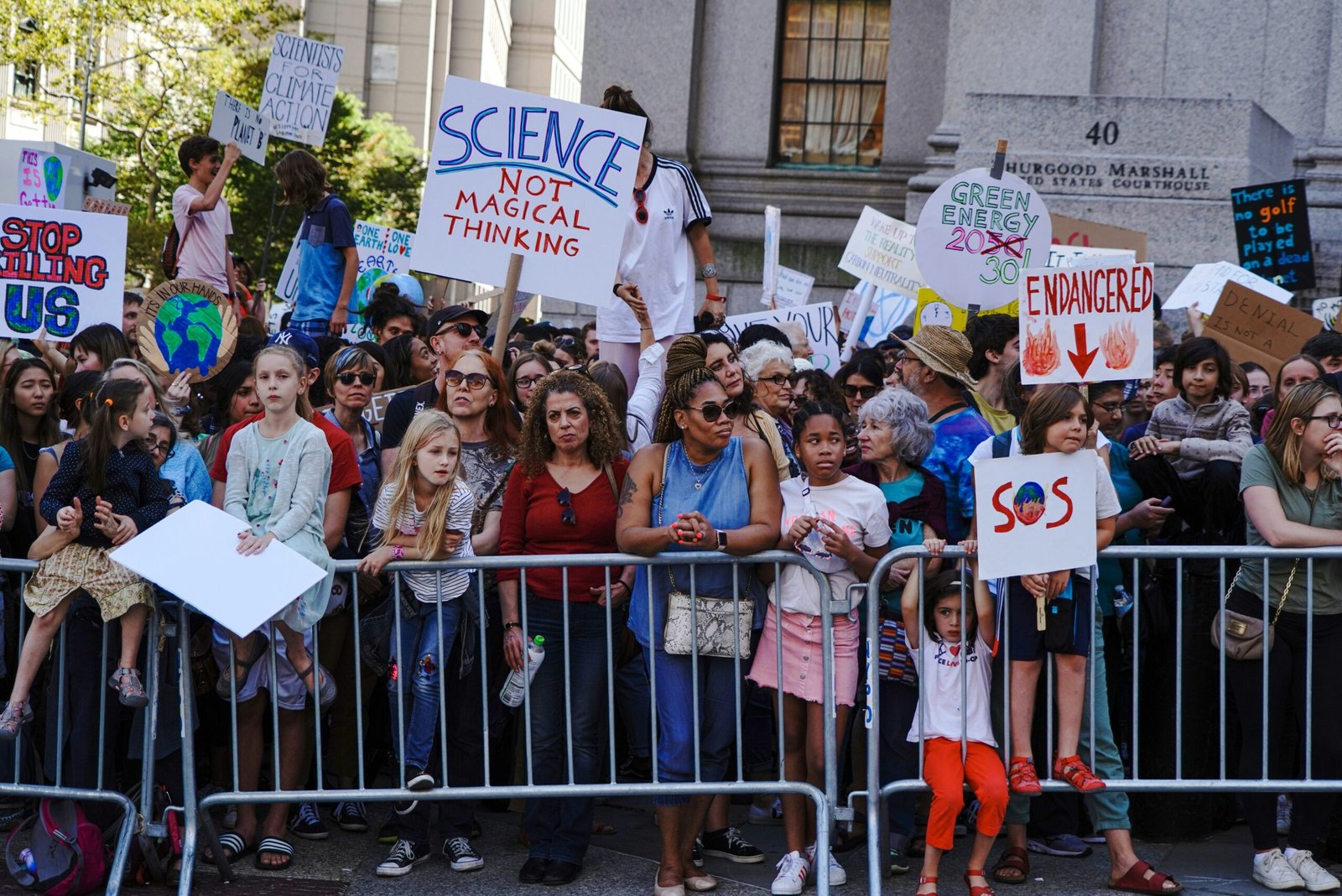 group of people holding white and blue banner doing climate activism
