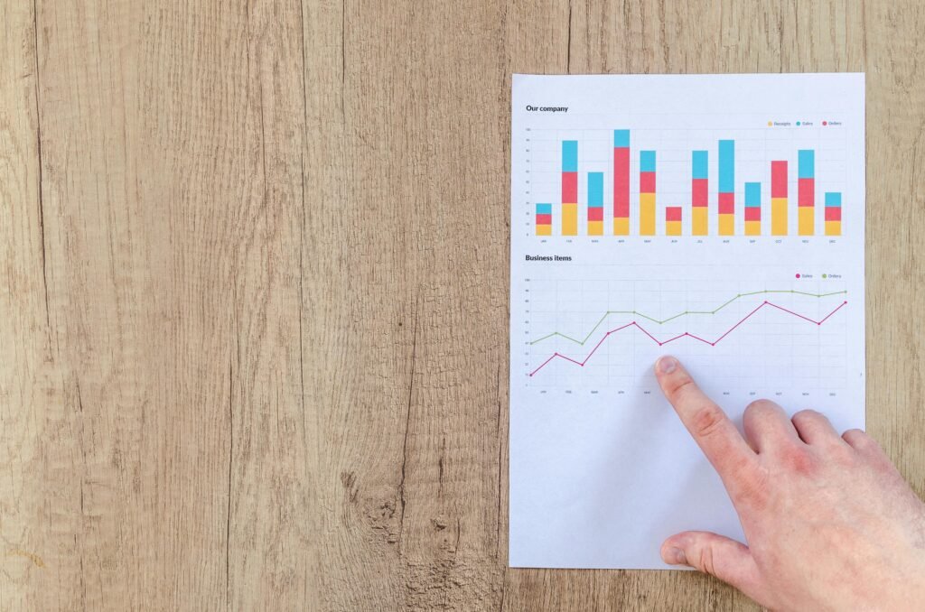 Person Pointing Paper Line Graph showing business doing calculations for carbon offset programs.