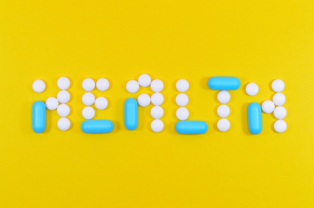 White and Blue Health Pill and Tablet Letter Cutout on Yellow Surface to show climate change and health impacts
