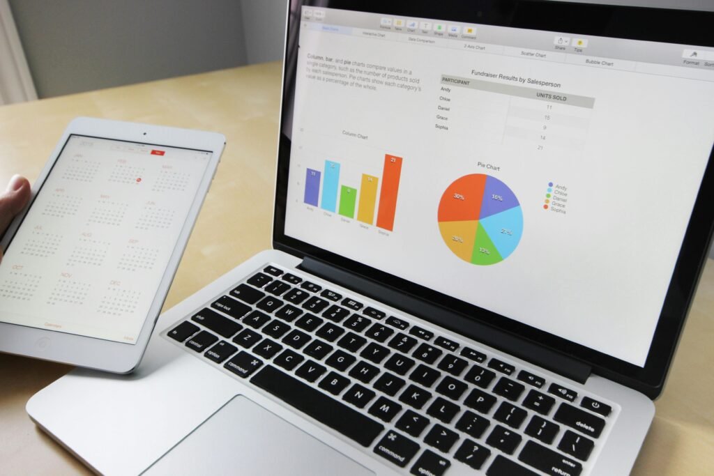 Laptop displaying charts and graphs with tablet calendar for data analysis and planning. Big data in climate prediction.