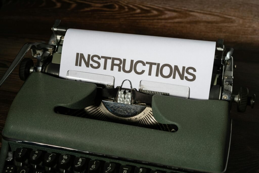 Close-up of a vintage typewriter printing the word 'INSTRUCTIONS' on paper sheet.