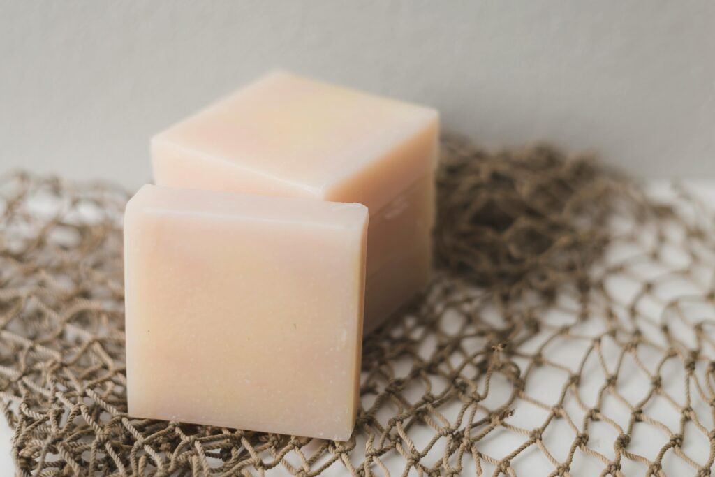 Two bars of natural handmade soap placed on a rustic netting backdrop, perfect for a spa theme, for eco-friendly morning routine.