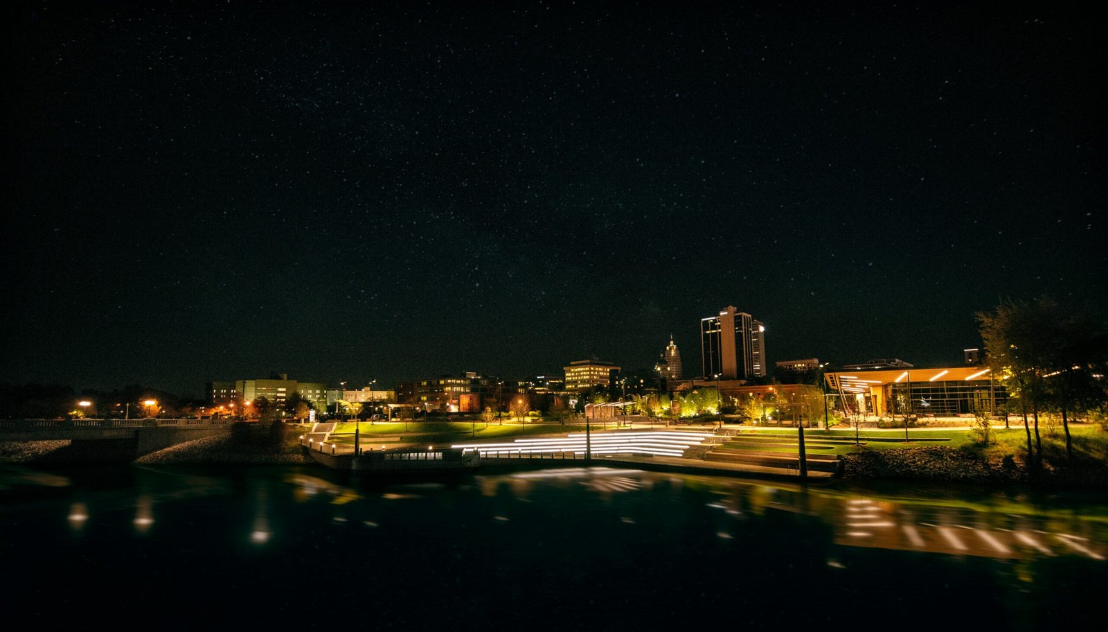 Captivating night view of Fort Wayne skyline with illuminated city lights and clear starry sky. Take the lights out challenge