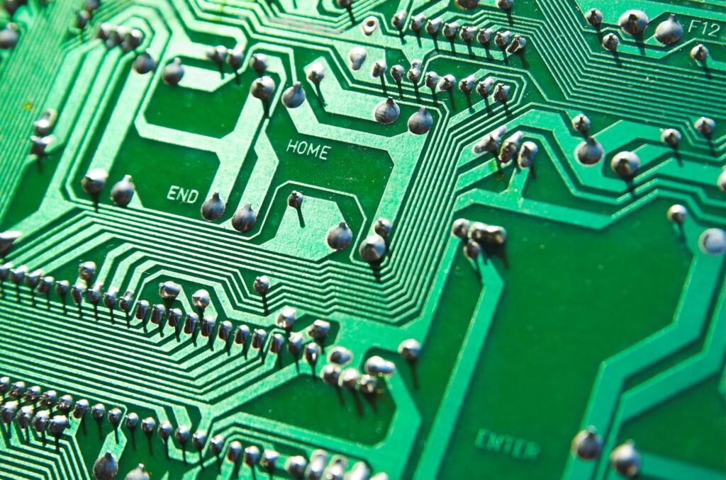 Detailed view of green circuit board with visible chips and pathways, highlighting technology elements.